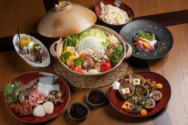 「日式火鍋雙人套餐」以柴魚湯頭為主，搭配生魚片、甜點與蔬菜盤等，可選擇肉片或是圖中的海鮮盤。業者提供