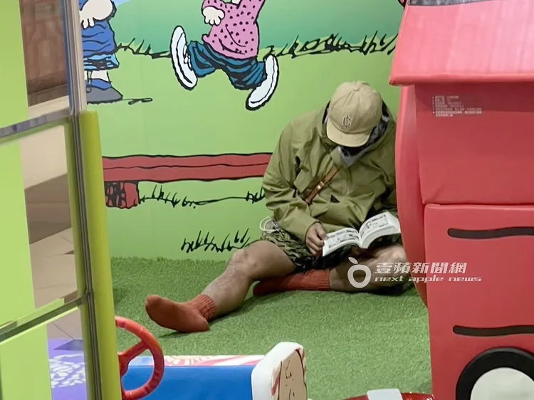 張震嶽走到樂園一角落，坐在地上相當投入的看起漫畫。特勤中心攝