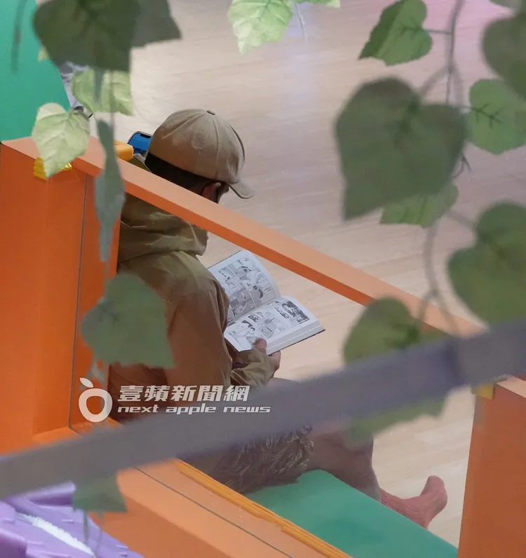 似乎地板坐久了有些痠痛，張震嶽走到入口處旁的座位上繼續看漫畫。特勤中心攝