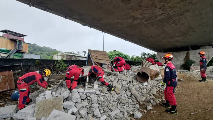 義消特搜人員在瓦礫堆中搜尋。新北市消防局提供