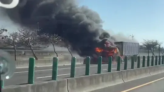 路過車輛拍下大貨車車頭著火燃燒，濃煙直竄天際景象。取自記者爆料網