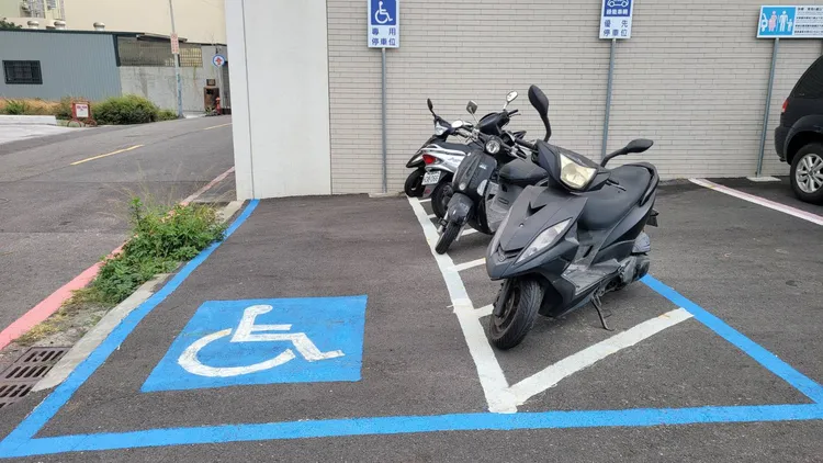 民眾仍將機車停入無障礙停車格內。劉榮輝攝