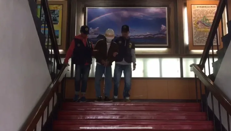 張男自首被警方上銬逮捕。成功分局提供