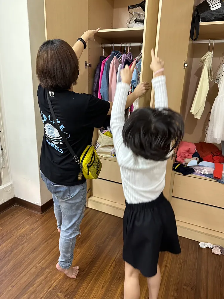 小情（右）開心地向媽媽展示自己在安置機構裡的小衣櫃。社會局提供