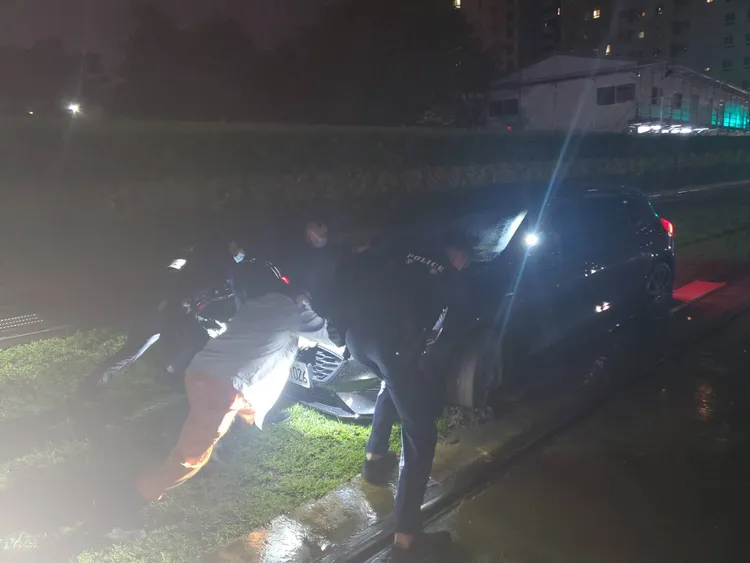 警方協助輕軌工作人員，將趙姓男子的汽車推離軌道。讀者提供