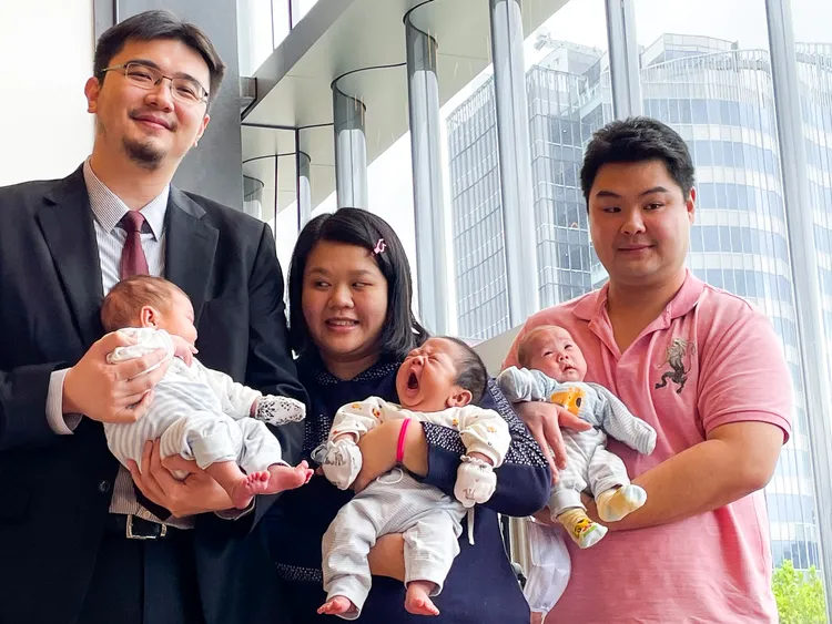 李毅評（左）與三胞胎父母合照。賴昀岫攝
