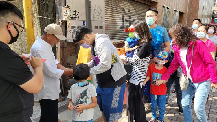 廖大乙發放領取米母號碼牌。劉榮輝攝