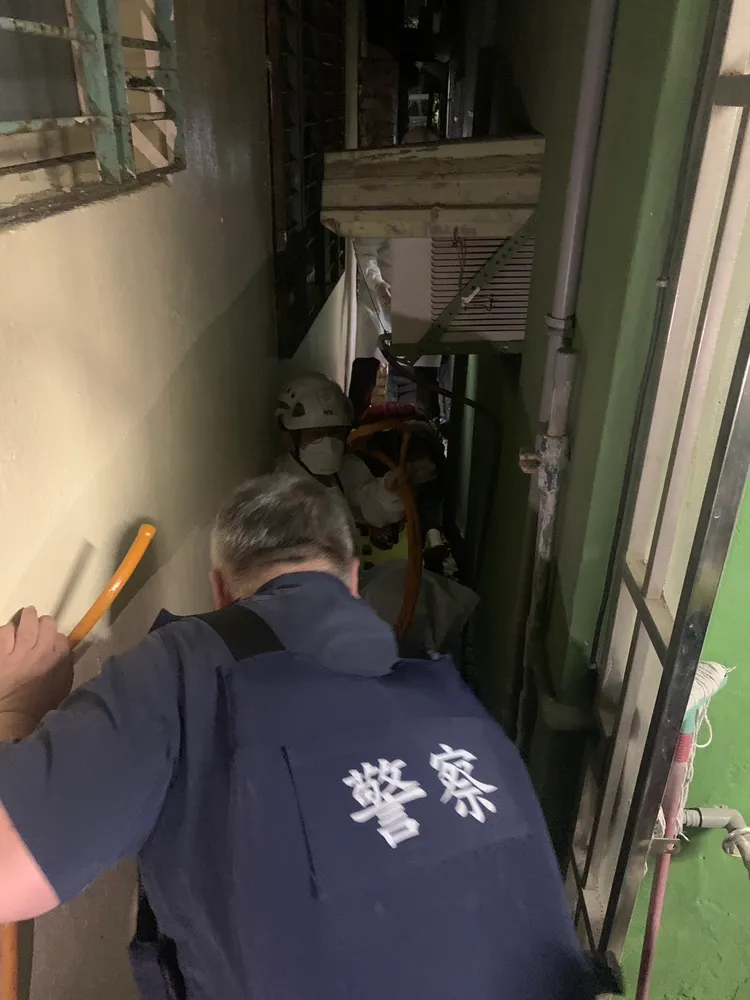 蔡姓婦人路倒在狹窄的防火巷，身體下又是破碎的木板和水溝，救援難度相當高。讀者提供