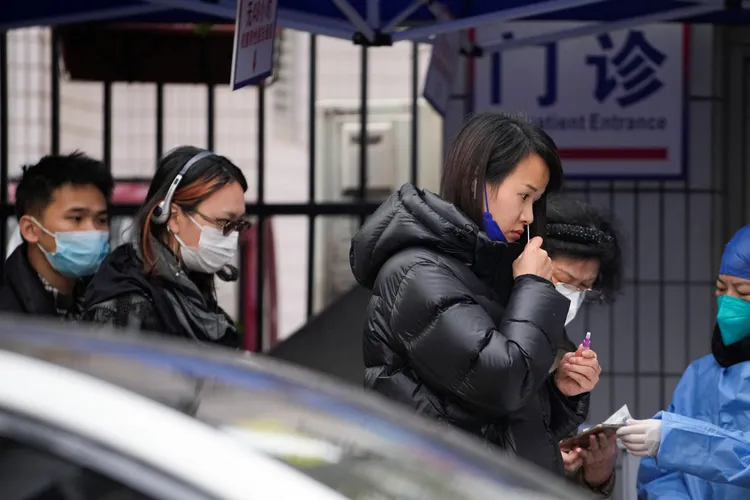 上海市民12日在一所醫院外排隊接受快篩檢測。路透社
