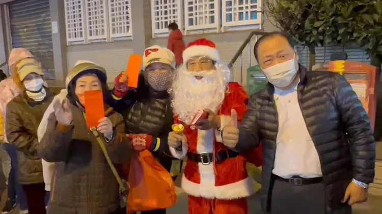 領到紅包的民眾開心與聖誕老人合影。許逸民攝