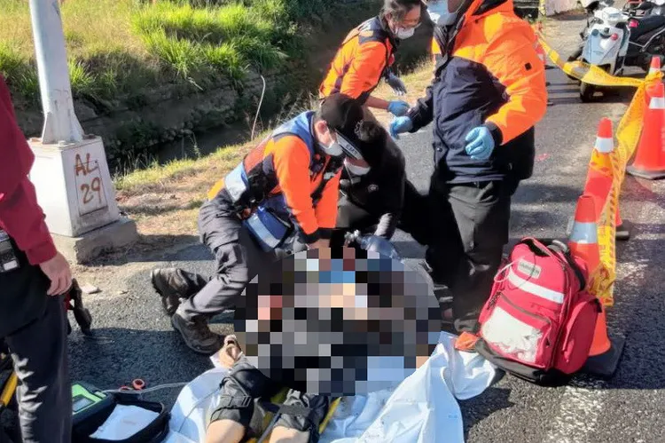 警消將人抬上路邊，進行急救。讀者提供