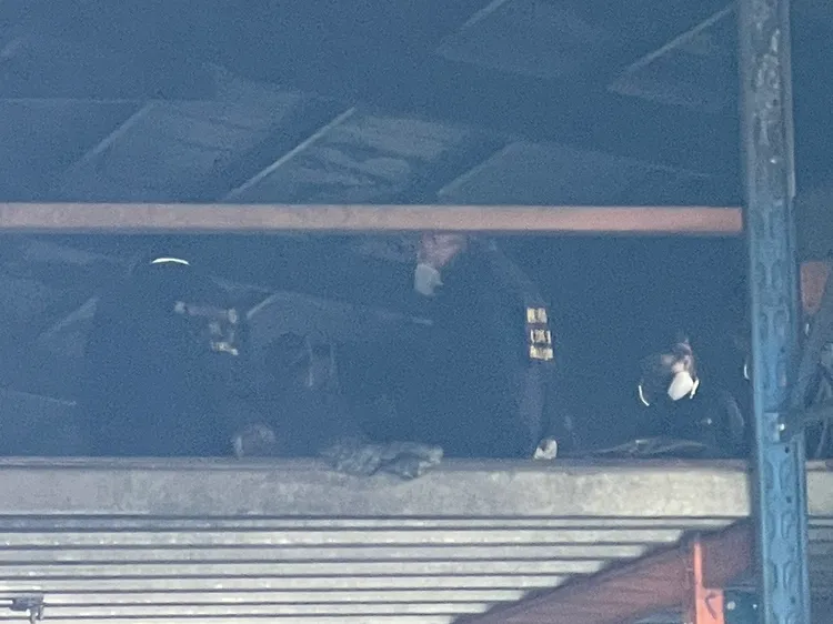 鑑識人員進入倉庫夾層勘驗。王煌忠攝