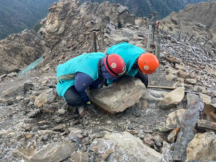 巡查員在嚴寒的氣候下，搬除道路上的落石。玉管處提供