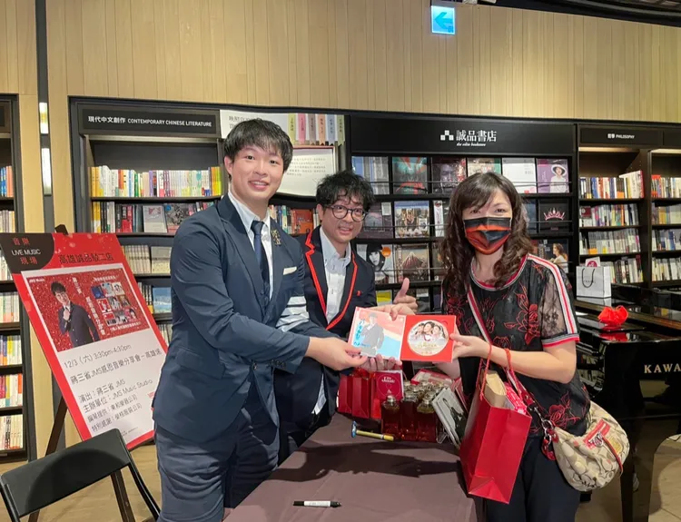 蔣三省（中）與兒子蔣榮宗（左）一起簽名。蔣三省工作室提供