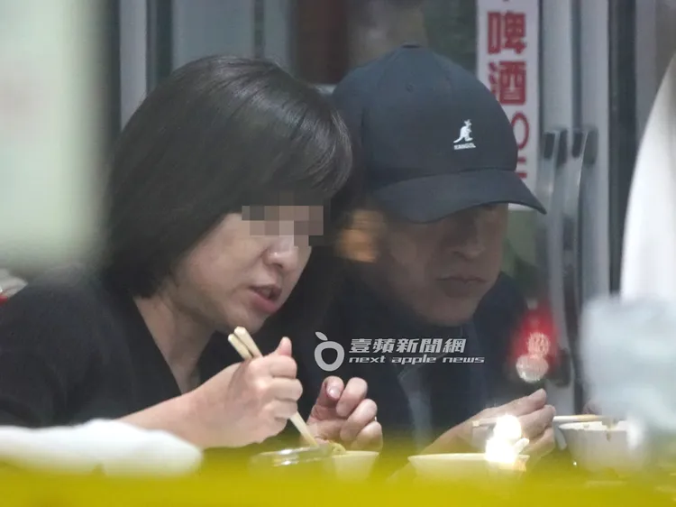 謝震武（右）一邊聽著OL話家常，一邊拿著筷子進食。特勤中心攝