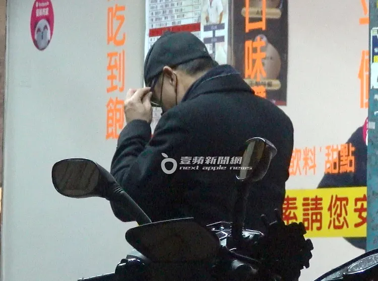 謝震武走到一旁戴上眼鏡，拿著雨傘等待OL埋單。特勤中心攝