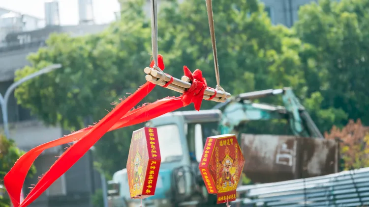 怪手將安放屋頂最高的一根中樑移至屋頂處。古和純攝