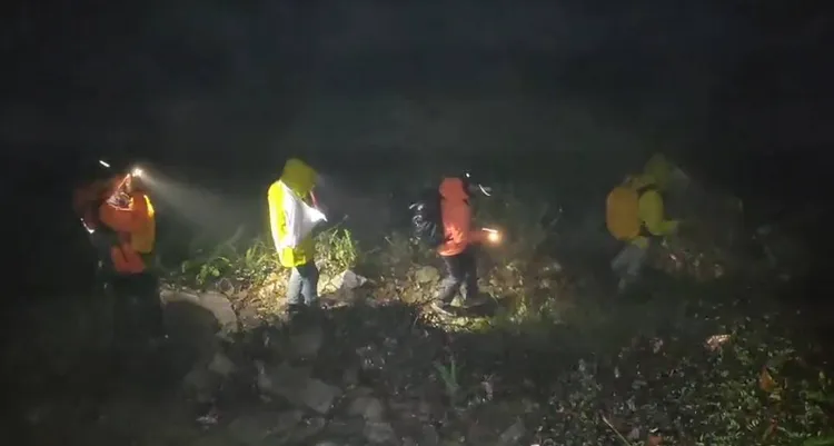 搜救人員冒雨前往救援，在步道上接觸傷者後護送下山。民眾提供