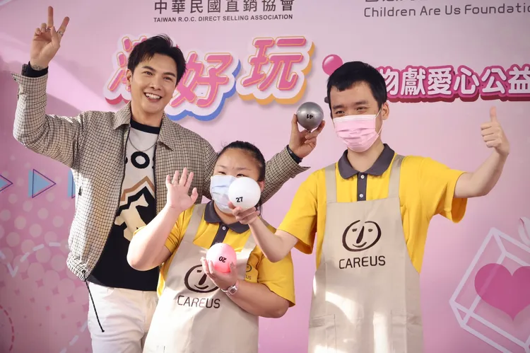 謝佳見（左）和喜憨兒一塊玩夾娃娃。林林攝