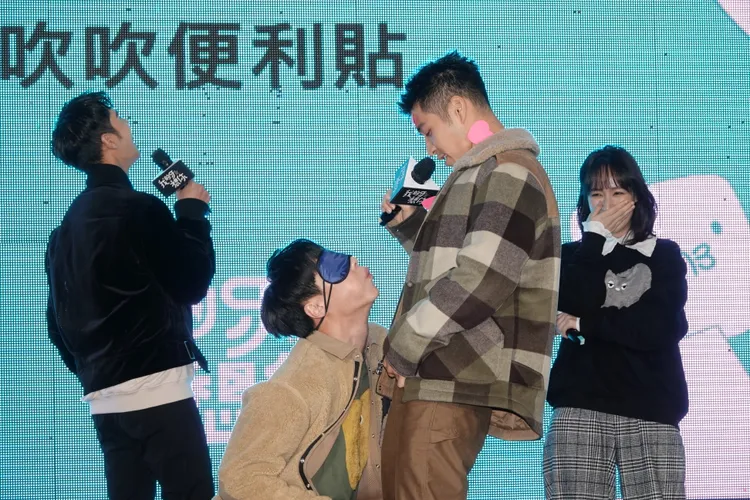 余晉（左二）玩遊戲認真吹掉吳岳擎身上的便利貼。陳德興攝