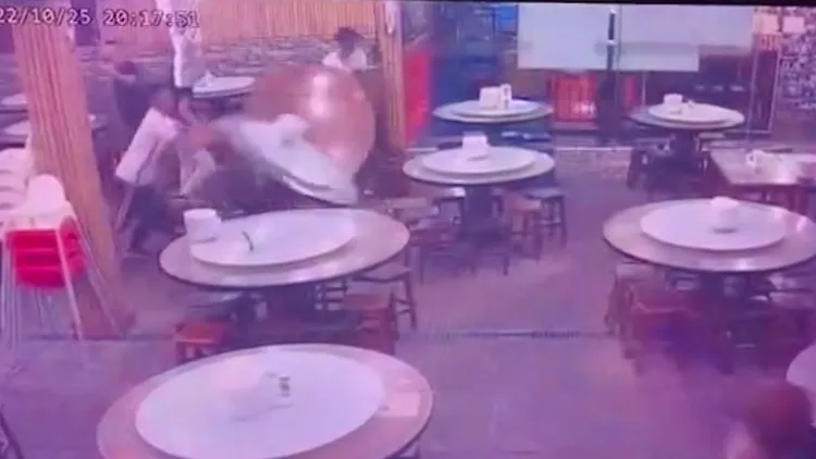 男子邊拿手機錄影邊掀桌。讀者提供