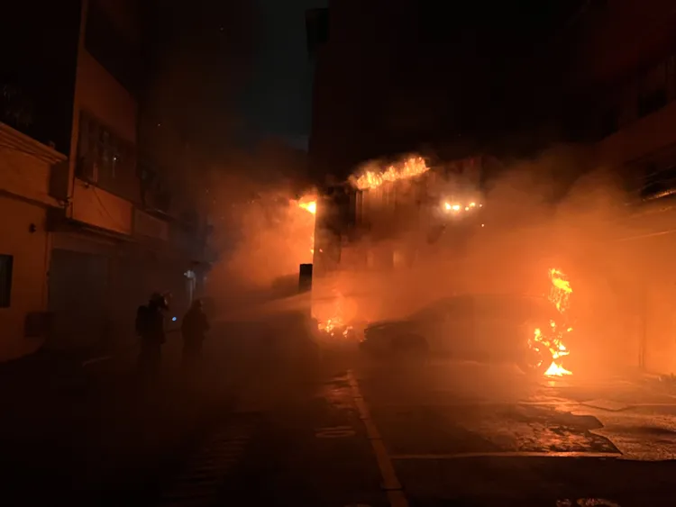 空屋的火勢驚人，旁邊還停放一輛汽車，消防人員冒險滅火。讀者提供