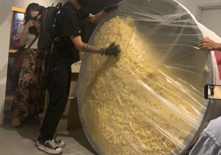 男子以塑膠膜與膠袋將桶子封住。吳慧芬攝