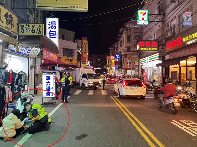 事故發生後，消防人員仍繼續檢視自摔女騎士（紅圈處）傷勢。讀者提供