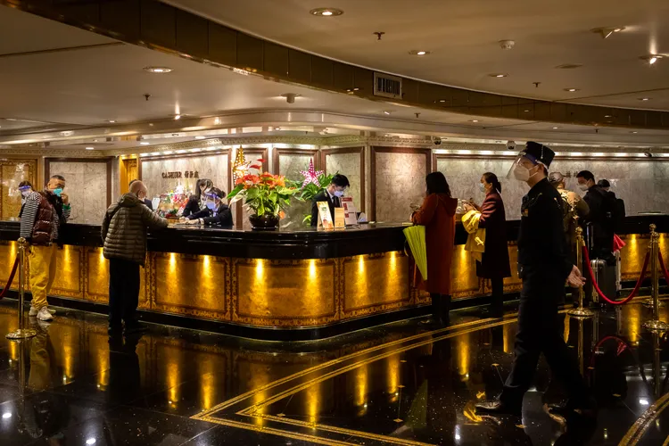 圖為旅客16日在澳門一家旅館辦理入住手續。法新社