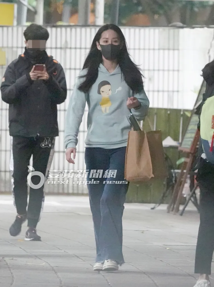 曾愷玹拎著裝有包裝紙和零食的環保購物袋走在街上。特勤中心攝