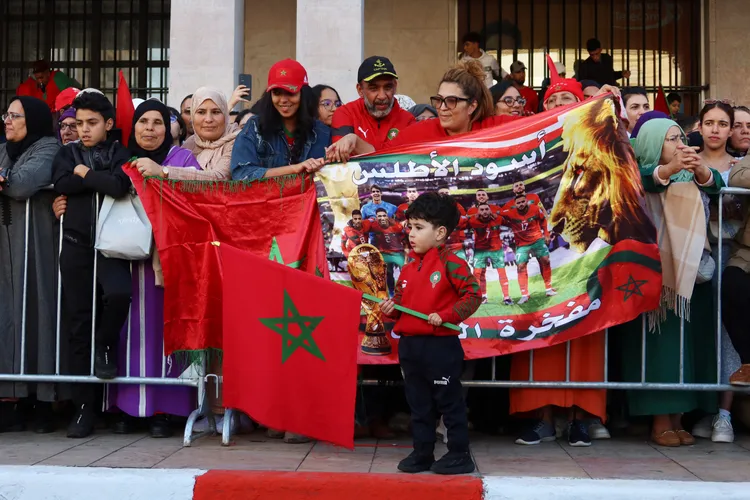 有民眾自製布幅表達歡迎隊員回國，小男孩也拿著國旗揮舞。路透社