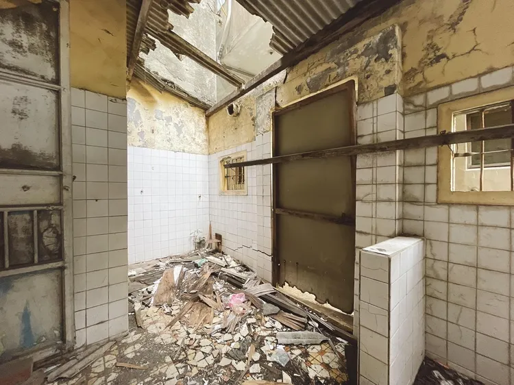 該房鋼筋外露，牆壁有明顯裂縫和脫落痕跡。翻攝臉書大高雄房屋買賣網