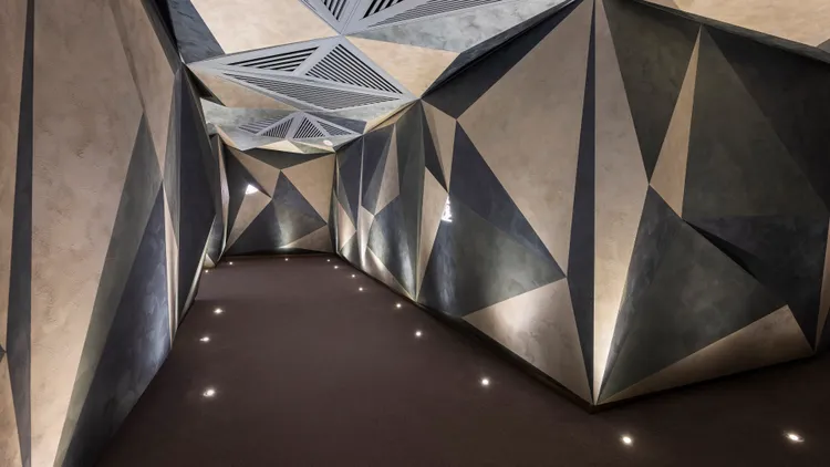 連通大廳與梯廳的通道，以洞穴隧道為意象，穿越其中能身歷其境感受到漫步在山林的感覺。阿里山英迪格提供