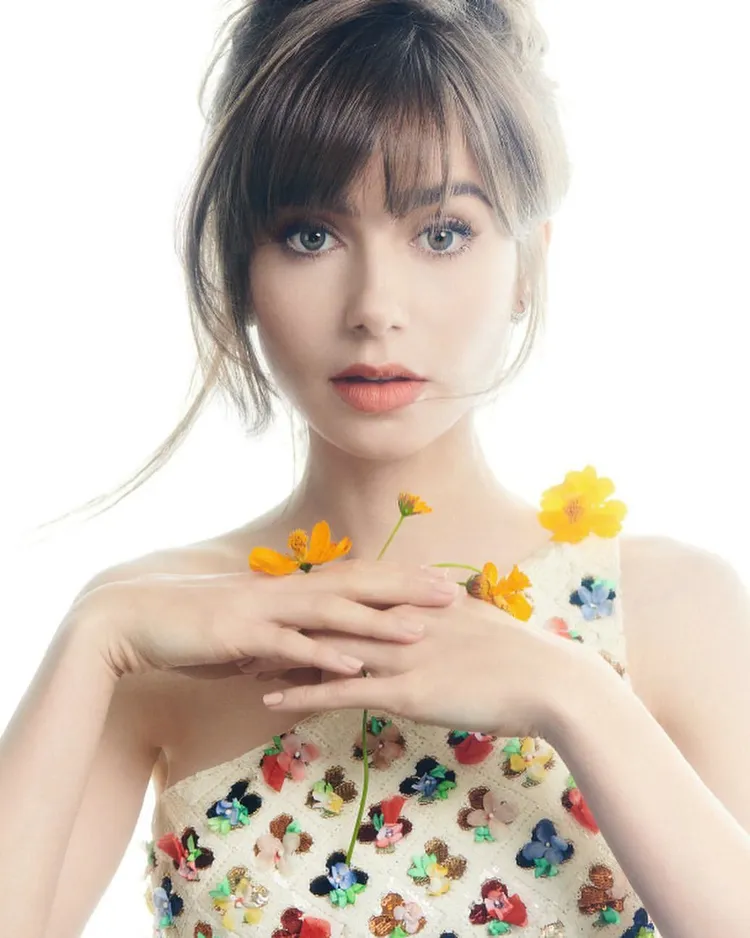 在時尚雜誌《Harper’s BAZAAR》德國版1月號中，柯林斯輕盈蓬鬆的劉海，搭配法國精品香奈兒2023早春系列花朵斜肩上衣，既甜美又空靈。翻攝lilyjcollins IG