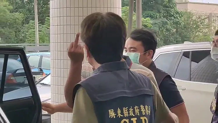 楊姓男子被警方移送檢方時，上車前對拍攝媒體比中指。民眾提供