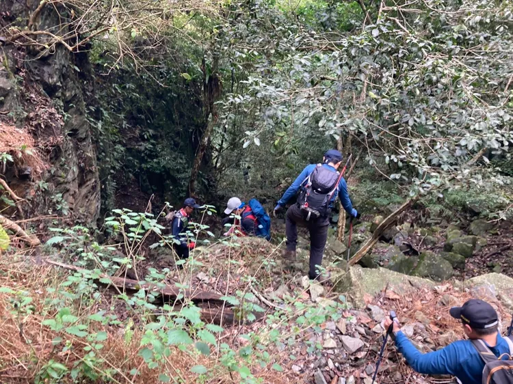 搜救人員將鄭男帶離峭壁區。李陳信得攝