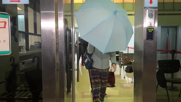 女子拿傘為歐男遮臉。陳彩玲攝