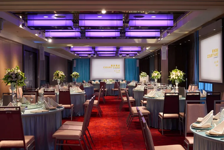 台北六福萬怡酒店九樓宴會廳，以正紅色絨質地毯搭配可調式造型燈光，打造中式婚宴風。六福旅遊集團提供