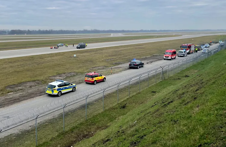 德國警方派出人員車輛在機場跑道旁待命，因應環保人士的抗爭行動。路透社