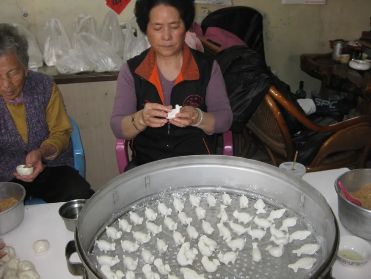 以米糰捏成「雞母狗仔」，再點上紅胭脂，蒸熟出爐後，才算完成。許逸民攝