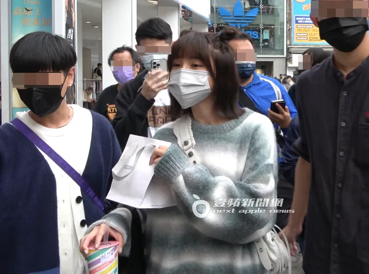 中信兄弟啦啦隊女神峮峮（中），出席代言老賴茶棧活動後，上樓更衣換上一件長版毛衣，在粉絲包圍下離去。特勤中心攝