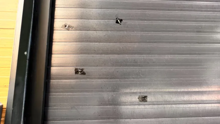 1樓鐵捲門留有4個彈孔。資料畫面