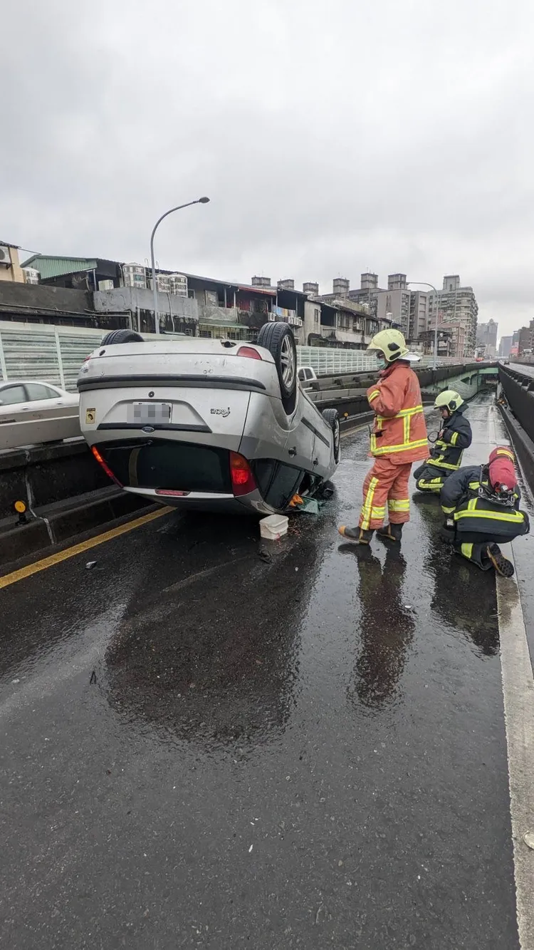 警消獲報趕抵救援，車上2人已自行爬出車外。新北市消防局提供