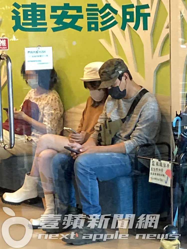 夏宇童（中）貼心陪著孫協志坐在連安診所內候診。特勤中心攝