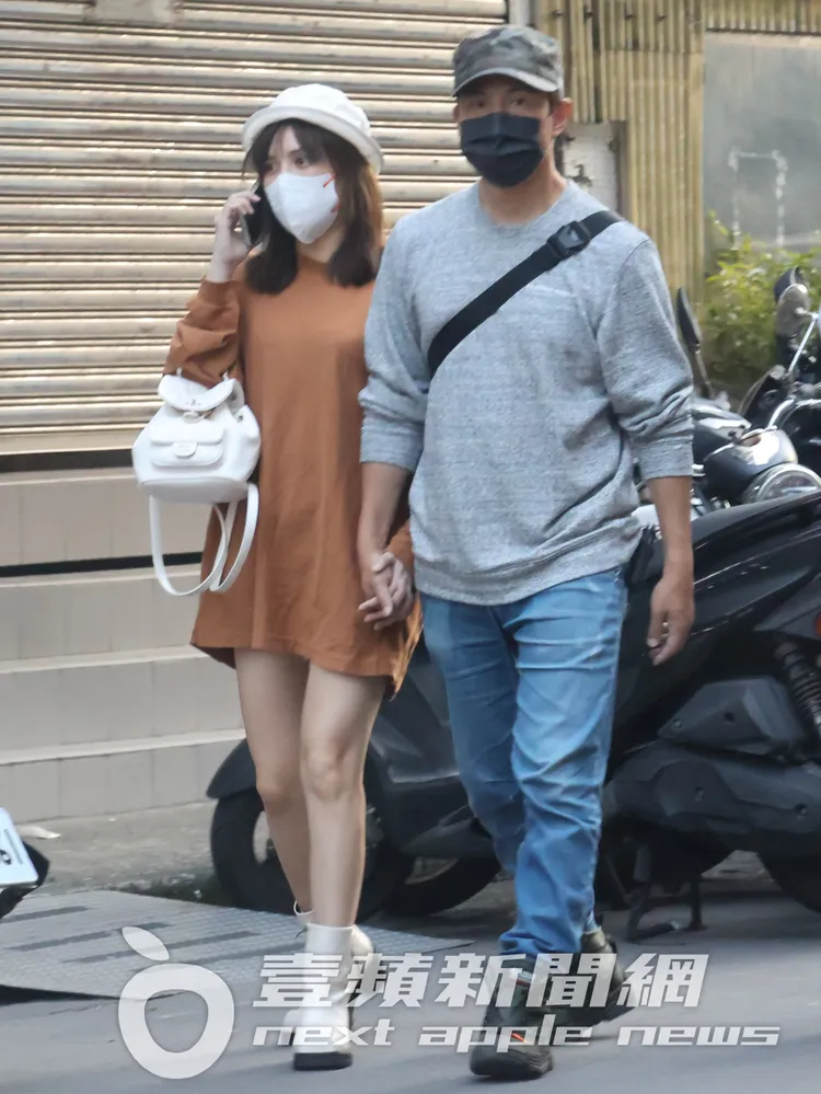 孫協志（右）看完病後，緊牽著女友夏宇童，她穿著寬鬆服裝，下半身失蹤「飄孕味」。特勤中心攝