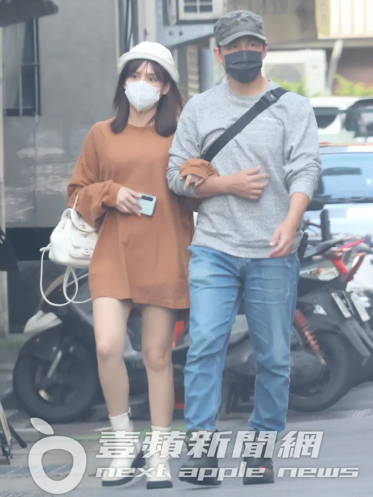 夏宇童（左）勾著孫協志的手漫步，衣著寬鬆的她下半身失蹤，不時用手護肚。特勤中心攝