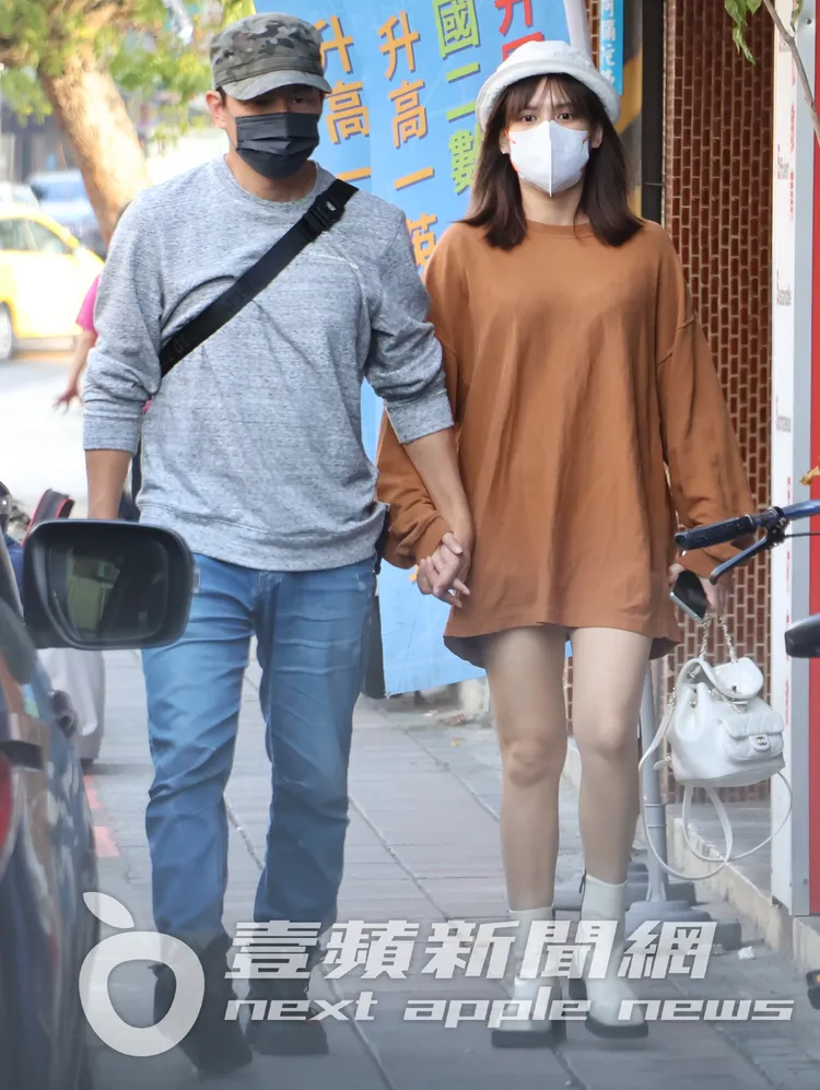 孫協志（左）和夏宇童十指緊扣散步，她衣著寬鬆下半身失蹤，另一手拿著香奈兒包。特勤中心攝