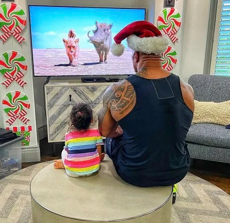 在家他就是女兒的大玩偶，他自曝這背影照片是他陪女兒看了「第987次」的獅子王。引自巨石強森IG