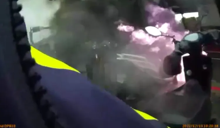 警方衝到火燒車現場，將尚未起火的機車拉開。翻攝畫面