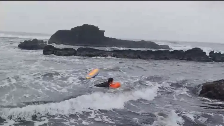 海巡施放動力救生圈將受困的衝浪客救回岸邊。讀者提供